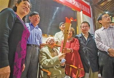 中國僑網徐文達老先生將火炬?zhèn)鹘o弟子,。(劉波 攝)