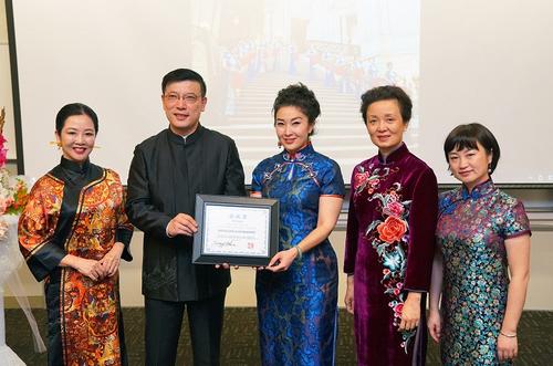 中國僑網(wǎng)駐舊金山總領(lǐng)事夫人喬力見證旗風(fēng)堂為旗袍文化聯(lián)盟頒發(fā)旗袍長卷完成證書。