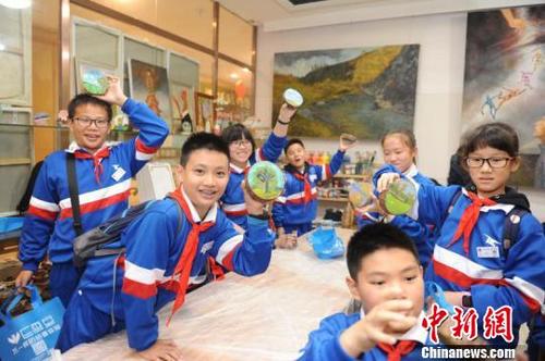 中國僑網(wǎng)圖為學(xué)生們展示畫好的木墩畫。