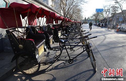 中國(guó)僑網(wǎng)資料圖:北京什剎海附近胡同里的“人力三輪車(chē)”??吭诼愤?,排成一排。中新社發(fā) 熊然 攝