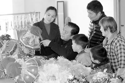 中國僑網(wǎng)11月25日,,章思林(左二)在“秧歌燈工作室”里修剪制作彩燈,。