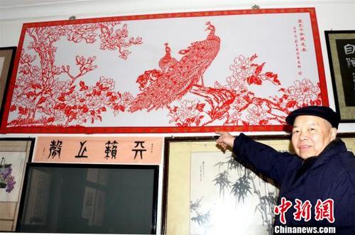 中國僑網(wǎng)78歲剪紙傳人張玉義完成的巨幅剪紙作品《萬紫千紅總是春》 宋俊初 攝