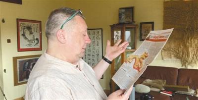 中國(guó)僑網(wǎng)皮特向本報(bào)記者介紹他在當(dāng)?shù)貓?bào)紙上刊發(fā)的一篇文章,。(本報(bào)記者 暨佩娟 攝)