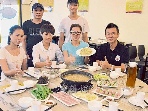 中國僑網(wǎng)鐘方香(坐者右2)向市民推介豬肚雞火鍋,。(馬來西亞《中國報》/趙詩綺 攝)