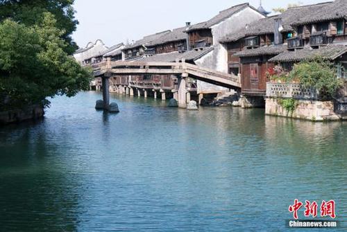 中國(guó)僑網(wǎng)資料圖,雖然已是入冬時(shí)節(jié),,但在江南水鄉(xiāng)烏鎮(zhèn),,金黃和深紅的樹(shù)葉、綠油油的蕩漾碧波,、白色的瓦房墻壁以及深色的屋檐構(gòu)成了一幅幅多彩的冬季圖畫(huà),。中新網(wǎng)記者 李卿 攝