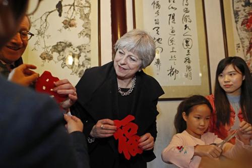 中國僑網資料圖:2018年2月2日,,特蕾莎·梅在上海參觀豫園,同孩子們一起剪紙,。(圖片來源:中新社)