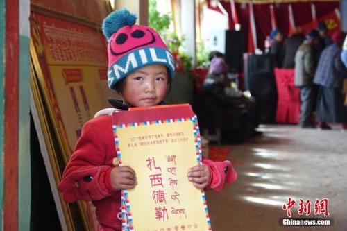 中國(guó)僑網(wǎng)資料圖:藏族小朋友手持春聯(lián),。孫翔 攝