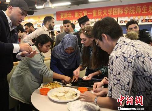 中國僑網(wǎng)圖為重慶大學(xué)留學(xué)生包餃子和湯圓共慶元宵節(jié),?!$娦馈z