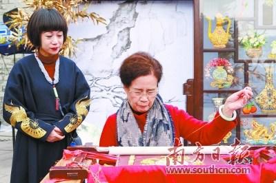 中國(guó)僑網(wǎng)潮州廣濟(jì)樓前,,康惠芳展示潮繡技藝,。南方日?qǐng)?bào)記者 蘇仕日 攝