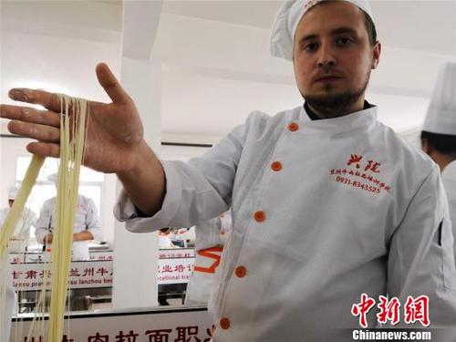 中國僑網(wǎng)圖為來自哈薩克斯坦的留學(xué)生赤龍展示拉出的“毛細(xì)”面型,。毛細(xì)是牛肉面中最細(xì)的一道面食,,成型后“細(xì)如發(fā)絲”,。 史靜靜 攝
