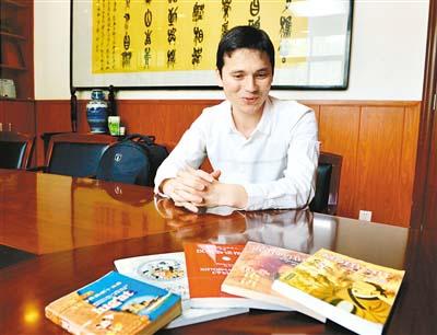 中國(guó)僑網(wǎng)烏茲別克斯坦留學(xué)生伊力哈穆和他編寫翻譯的與中國(guó)有關(guān)的書籍。(記者楊力 攝)