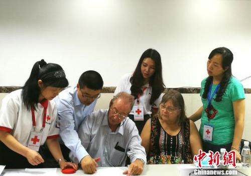 中國僑網(wǎng)圖為菲利普家人在翻譯和器官捐獻協(xié)調(diào)員的指導下填寫遺體器官捐獻志愿書。重慶市紅十字會供圖