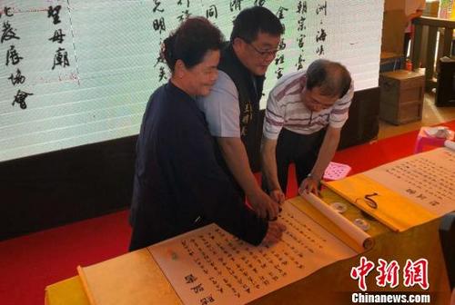 中國僑網(wǎng)“三門”宮廟代表在結盟書上蓋印?!£悙偂z