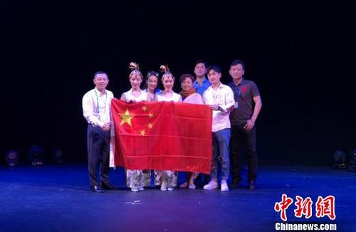 中國(guó)僑網(wǎng)圖為《傘叢扇影》節(jié)目組在美國(guó)比賽現(xiàn)場(chǎng)合影,?!≈貞c雜技藝術(shù)團(tuán)供圖
