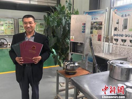中國僑網(wǎng)經(jīng)過6年的概念開發(fā)和產(chǎn)品規(guī)劃,、詳細(xì)設(shè)計(jì)、小規(guī)模生產(chǎn)等階段,李萬祥設(shè)計(jì)的第四代拉面機(jī)于2016年正式投產(chǎn)銷售,。圖為李萬祥和機(jī)器的合影。 艾慶龍 攝