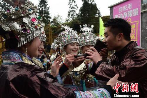 中國僑網(wǎng)苗族女孩在村口用牛角向來賓敬酒,?!⊥跻哉铡z
