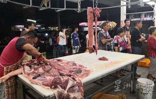 中國僑網(wǎng)員工在一旁的桌子上處理生豬,,但無阻食客在一旁耐心等候,,也成為一道風(fēng)景,。(馬來西亞《星洲日報》)