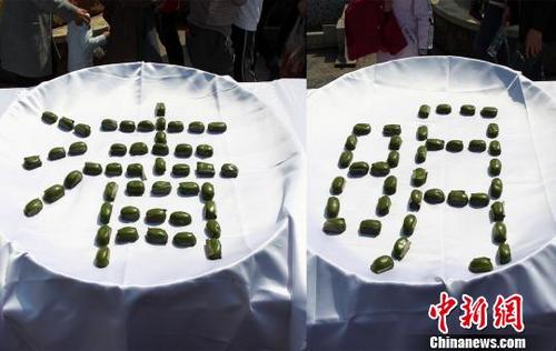 中國(guó)僑網(wǎng)圖為清明粑組合擺放成“清明”兩個(gè)字(拼圖),?!钚⒂隆z