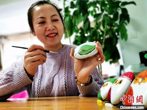 中國僑網(wǎng)圖為王海燕展示自己的石頭畫?!?zhí)砀,!z
