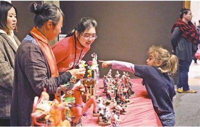 中國僑網(wǎng) 1月26日,美國國立亞洲藝術(shù)博物館舉辦中國農(nóng)歷新年家庭日活動,。圖為一名美國小朋友向中方人員了解中國面塑作品,。 本報記者 鄭 琪攝