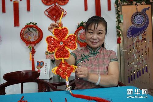 中國僑網(wǎng)5月21日,,天津市河北區(qū)非物質(zhì)文化遺產(chǎn)項(xiàng)目“巧妹紅妝繩藝”代表性傳承人呂敏展示其創(chuàng)作的作品,。(新華社/栗雅婷 攝)