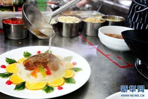 中國(guó)僑網(wǎng)范增福正在給八寶飯澆汁,。八寶飯作為“老八盤”中的熱菜之一,因其香甜的味道與軟糯的口感深受食客們的喜愛(ài),。(新華網(wǎng)/卡婭梅朵 攝)