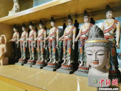 中國僑網8月底,甘肅敦煌八旬彩塑手藝人魯勤學的彩塑廠內,,展示柜上整齊地擺放著敦煌彩塑工藝品,。 閆姣 攝