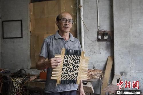 中國僑網(wǎng)謝世仰展示制作完成的竹編二維碼,。 彭莉芳 攝