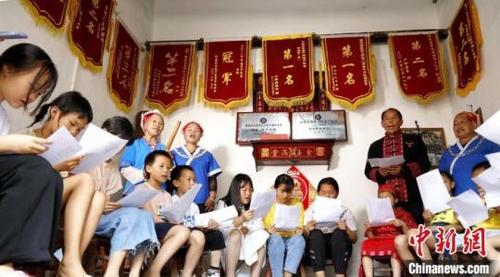 中國僑網(wǎng)吳通賢(后右二)給學(xué)生們教唱苗族“刻道歌”,。奉力攝
